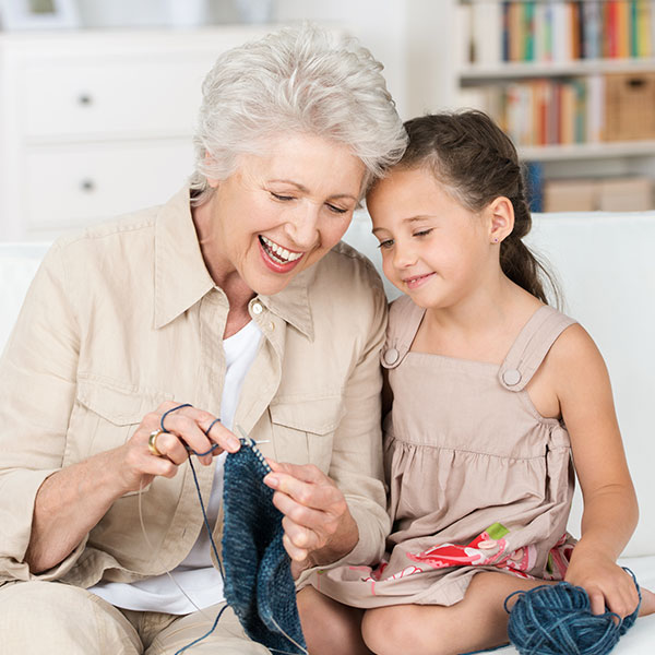 An older lady and a child knitting.